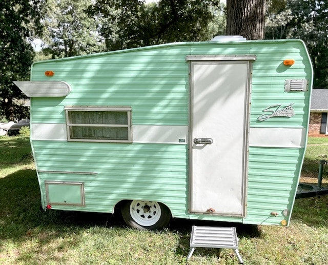 Life Is Good" text & a retro camper graphic on a green RV.|Discover this charming mint green vintage travel trailer