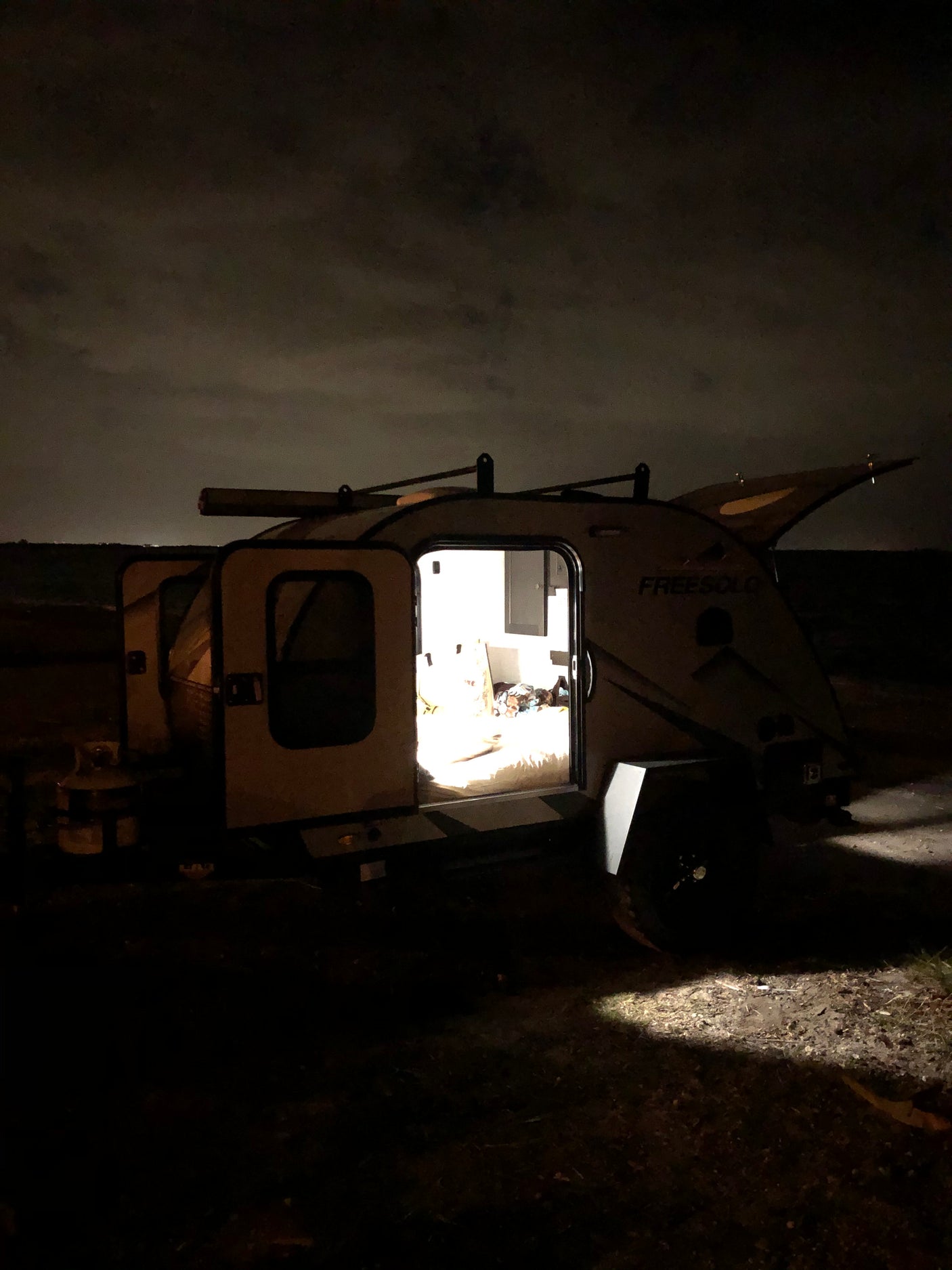Cozy 'FREESOLO' RV rental illuminated at night, ready for serene camping trips and outdoor adventure.