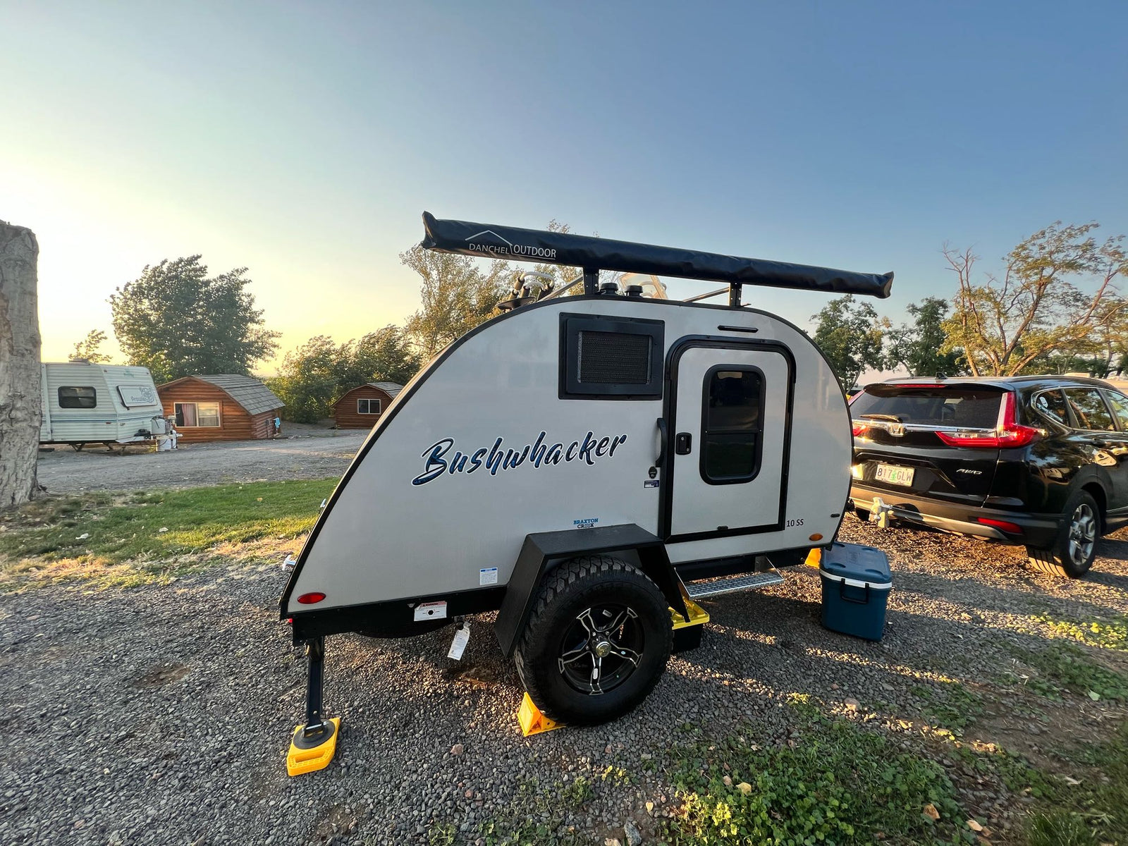 at an RV rental site with a snow-capped mountain backdrop.|Bushwhacker teardrop travel trailer