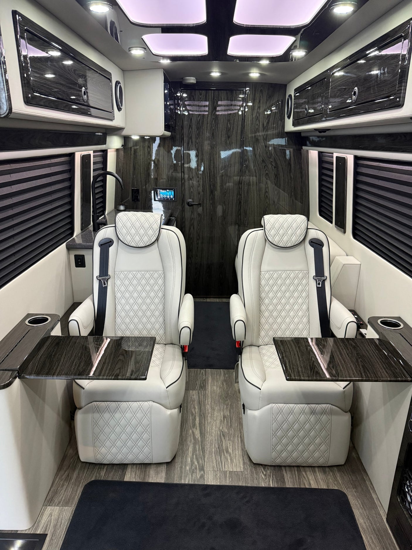 and elegant modern amenities.|Modern RV rental interior: plush white captain's chairs