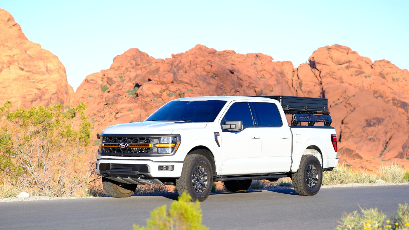 White Ford F-150 truck with an overland rooftop tent, ideal for an **rv rental** desert adventure among red rocks. — photo 13