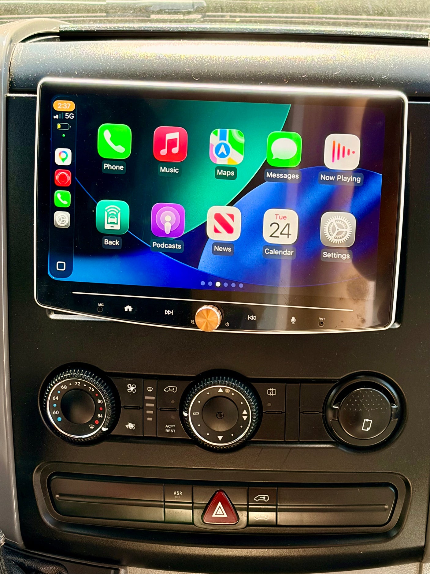 Inside an RV rental, a dashboard displays an Apple CarPlay screen, climate controls, and engaged hazard lights.