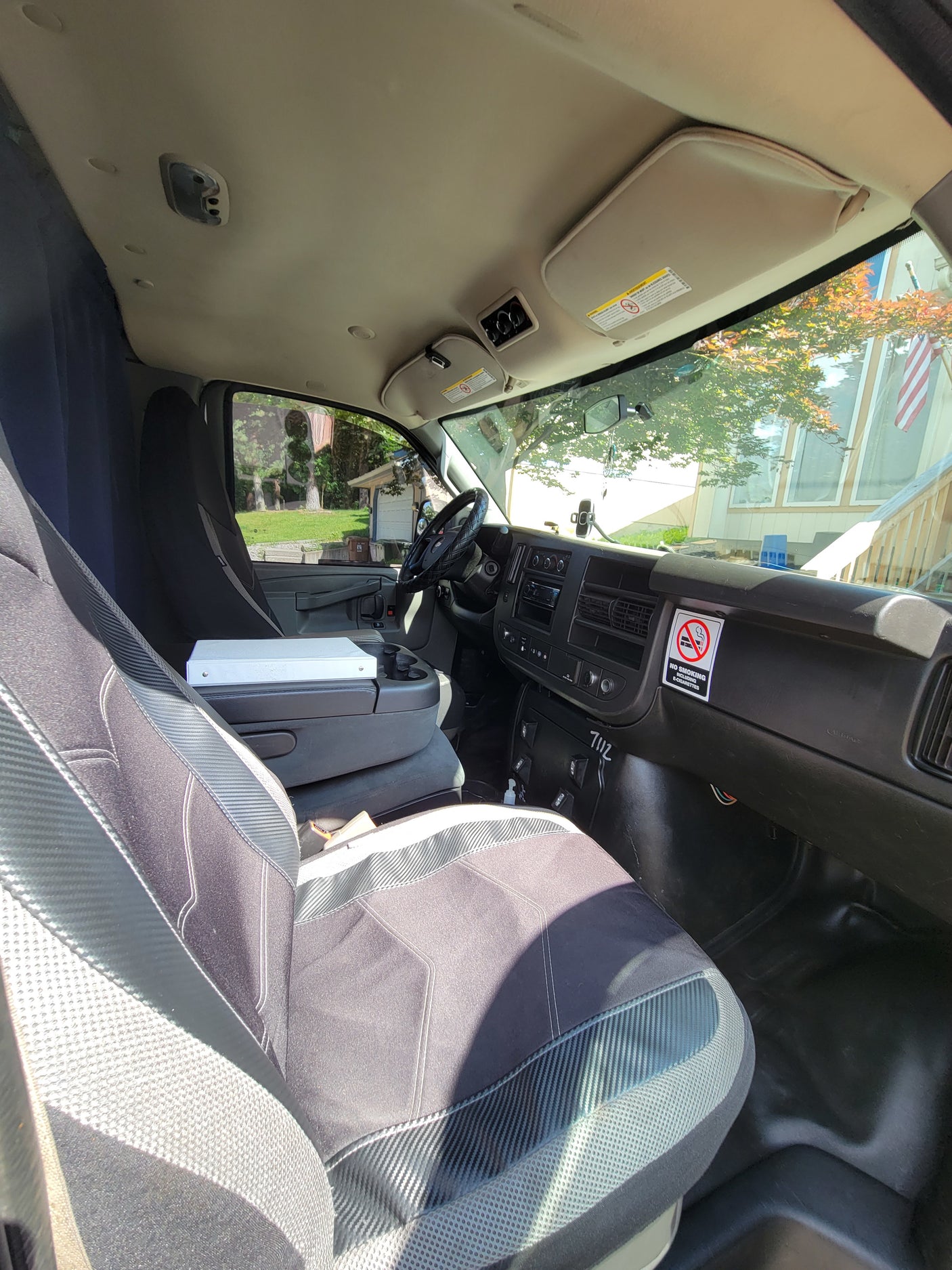 Interior of a practical vehicle cab, ideal for RV rental use. View from passenger seat shows dashboard, driver's area, and outside view.