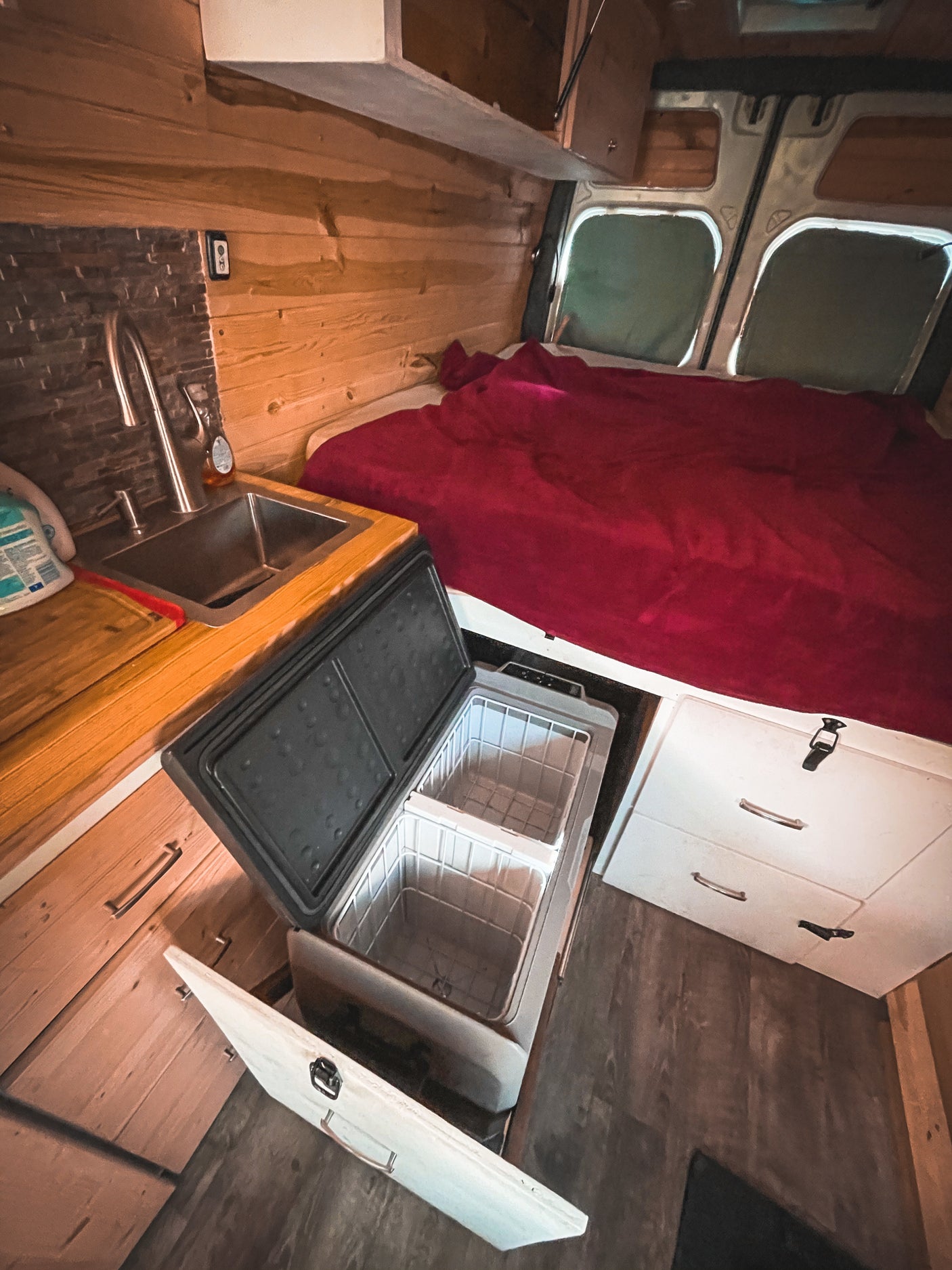 This inviting RV rental offers a compact kitchen, portable fridge, and full bed. Ideal for van life travel.
