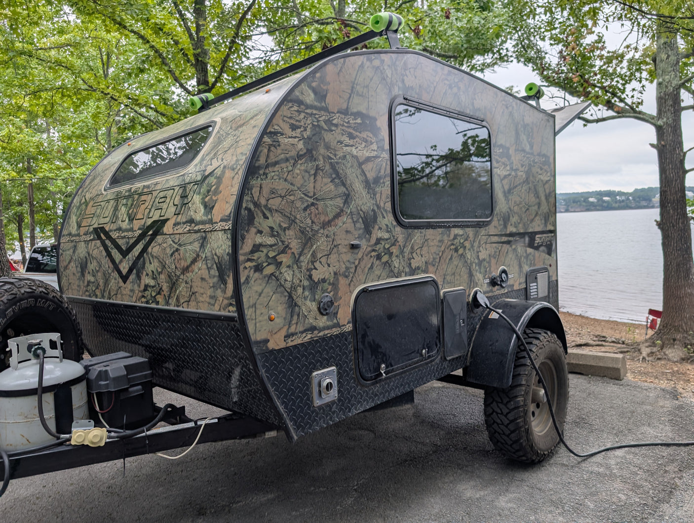 This rugged camouflage Sunray teardrop RV rental, perfect for lake camping, is powered up for adventure.