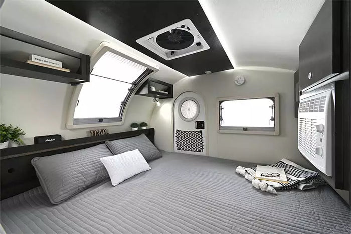 and storage. Ideal for camping.|A grey Jeep Wrangler tows a sleek nuCamp Boondock teardrop RV camper in a parking lot