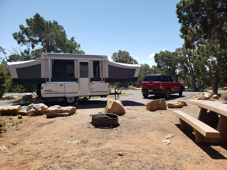 and a comfortable pop-up bunk bed.|Spacious RV rental pop-up camper interior. Two distinct bed areas with ample curtains and storage are visible.|Cozy RV rental pop-up camper interior