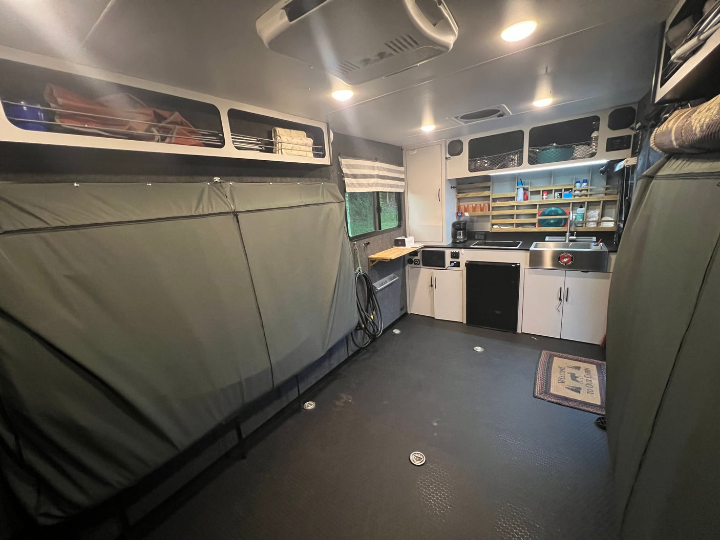 RV rental interior featuring a full kitchen, bed setup, and ample storage for comfortable adventures.