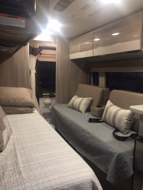 Cozy rv rental interior with two comfortable sleeping areas and modern cabinets.