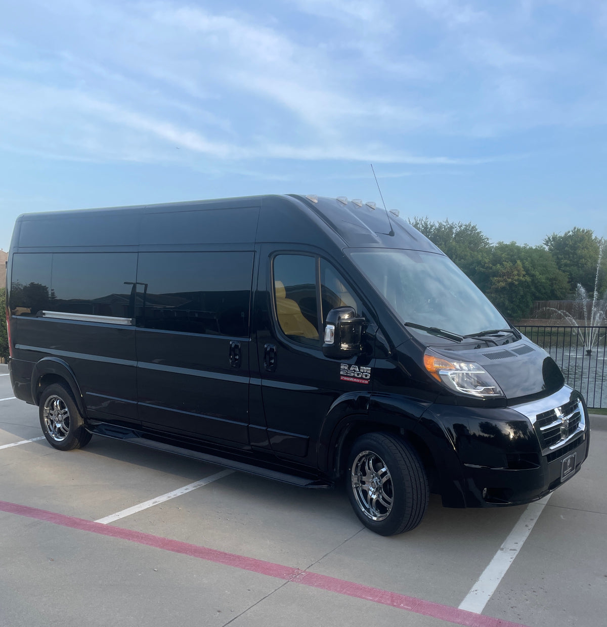Luxury black RAM Promaster van, suitable for rv rental. A spacious travel vehicle parked under a blue sky.