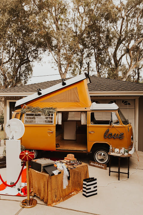 Experience fun with this vintage orange VW bus rv rental, transformed into a unique photo booth with props & instant cameras. — photo 6