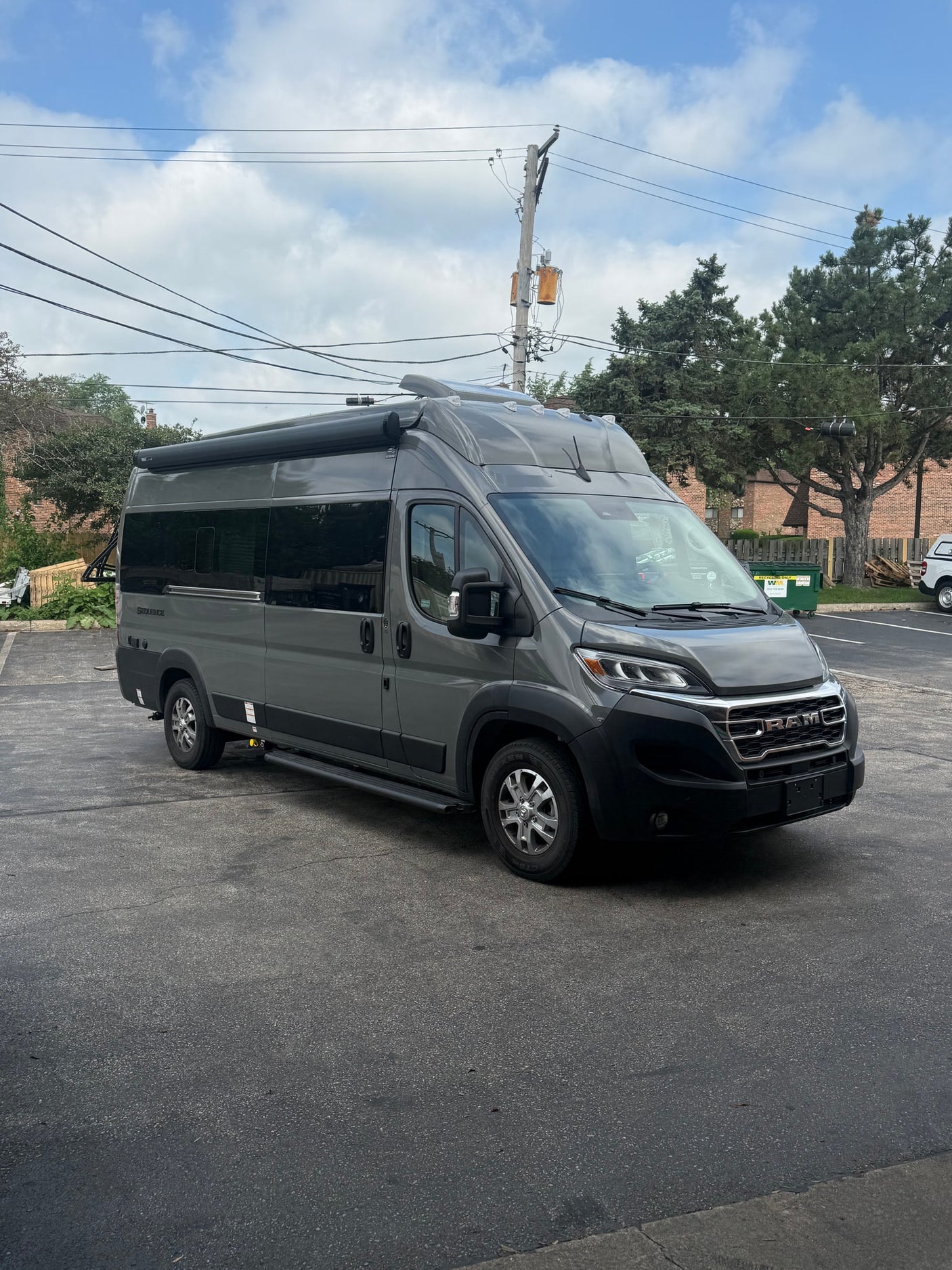 A gray Thor Motor Coach Sequence camper van, a popular RV rental, is parked outside, ready for adventure.