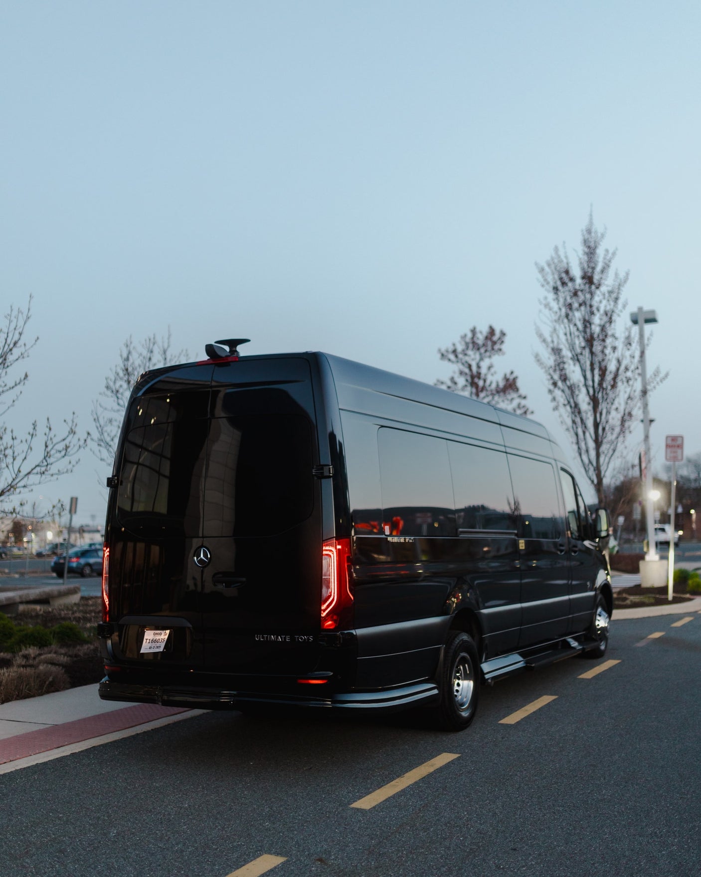 Black luxury Mercedes Sprinter van by Ultimate Toys, an ideal RV rental, parked at dusk.