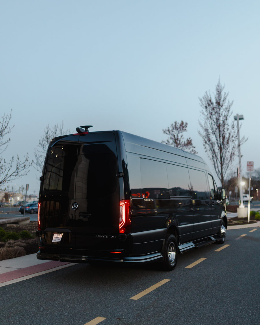 Black luxury Mercedes Sprinter van by Ultimate Toys, an ideal RV rental, parked at dusk.