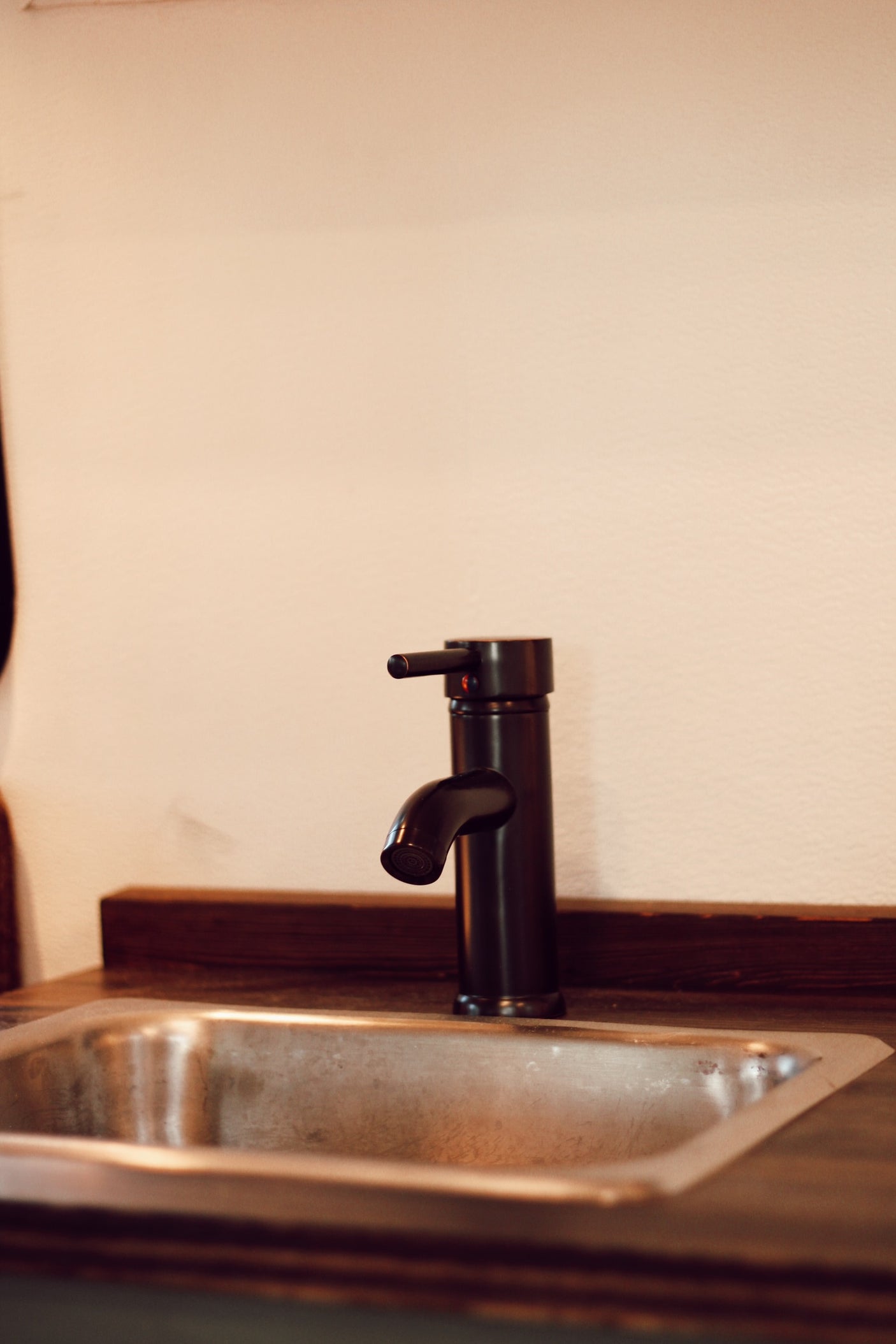 Modern black faucet & stainless steel sink in a compact RV rental kitchen.