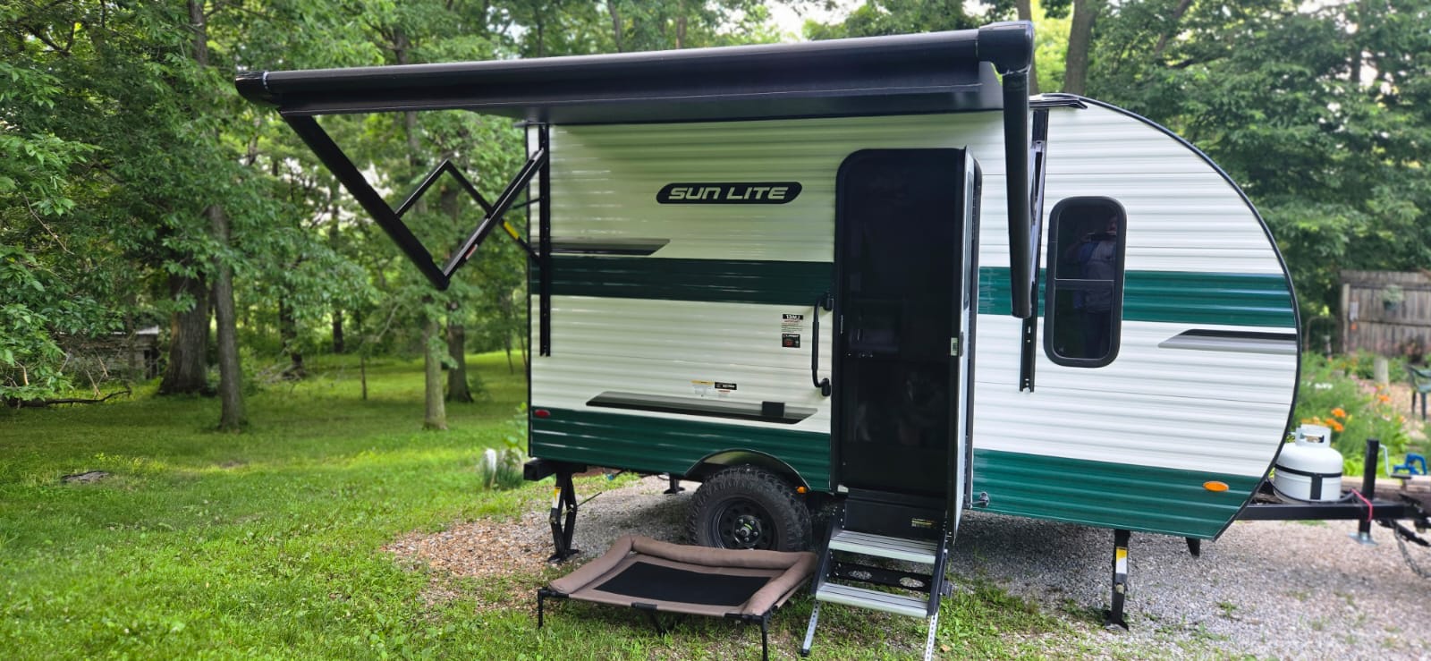 This Sun Lite RV rental features a cozy camper with an extended awning and pet bed