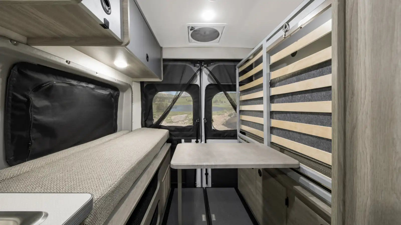 and a bench offer comfy travel space.|Modern RV rental interior featuring a kitchenette with sink