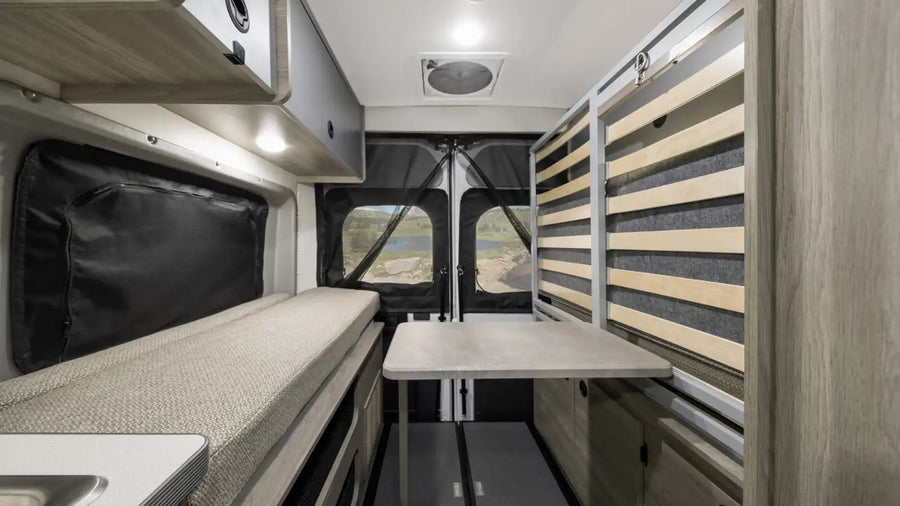 and a bench offer comfy travel space.|Modern RV rental interior featuring a kitchenette with sink