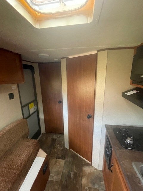 and sink on a countertop with wooden cabinets.|RV rental interior: window AC