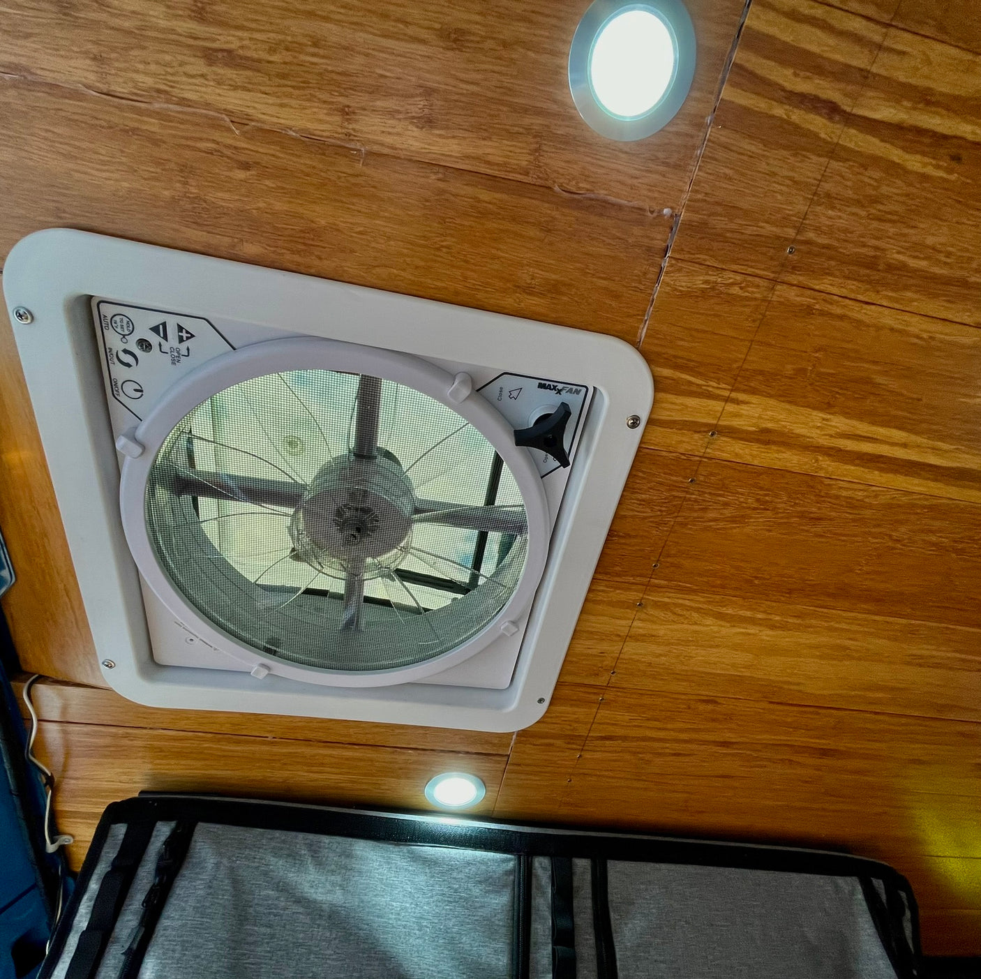 Inside an RV rental: a wooden ceiling features a MaxxAir fan with accessible controls and bright LED lights for comfort.