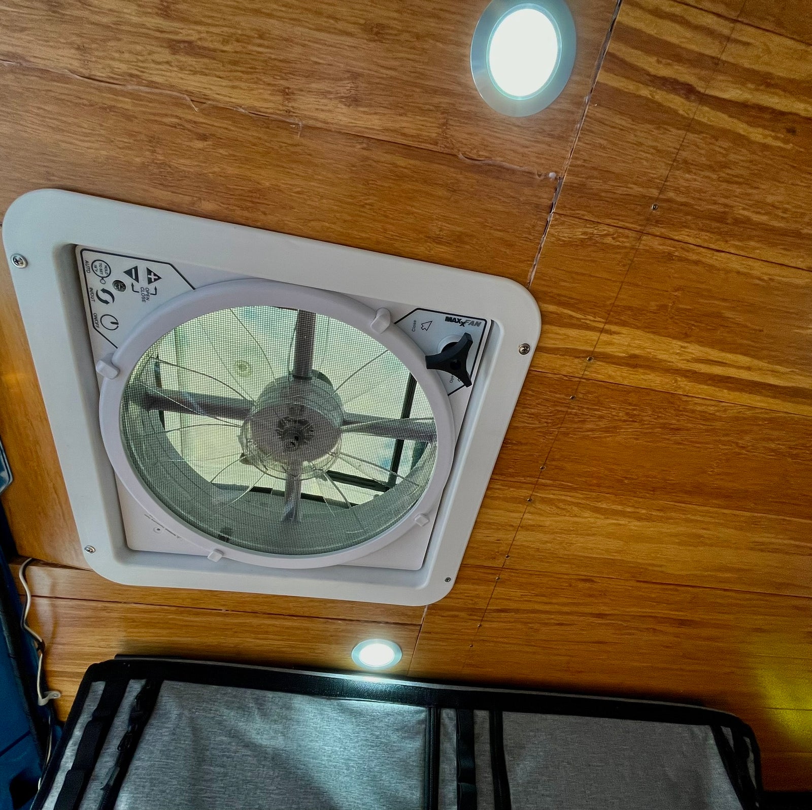 Inside an RV rental: a wooden ceiling features a MaxxAir fan with accessible controls and bright LED lights for comfort.
