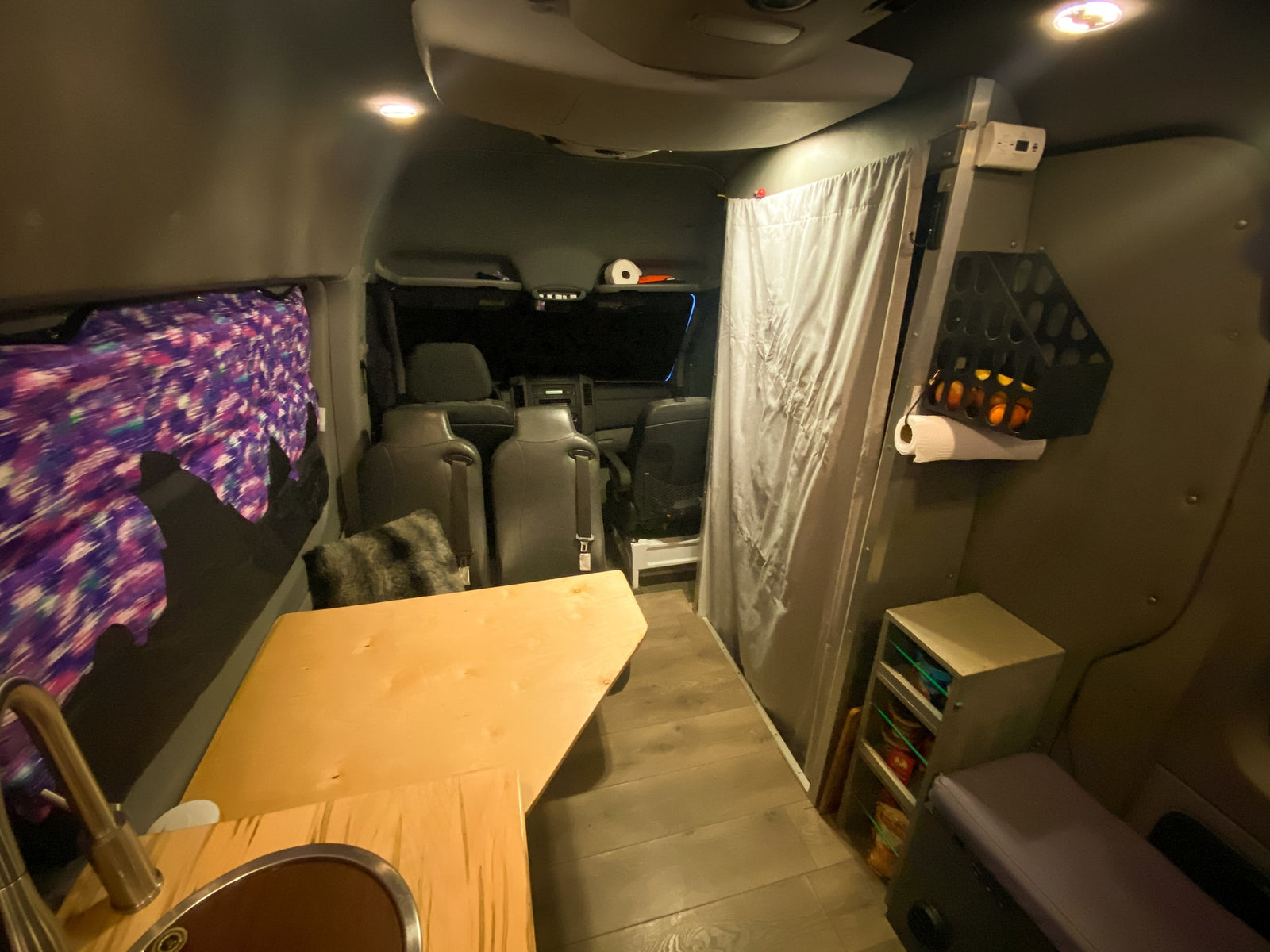 Inside a spacious **RV rental**: full kitchen with sink, comfy seating, clever storage, and cozy lighting for adventure.