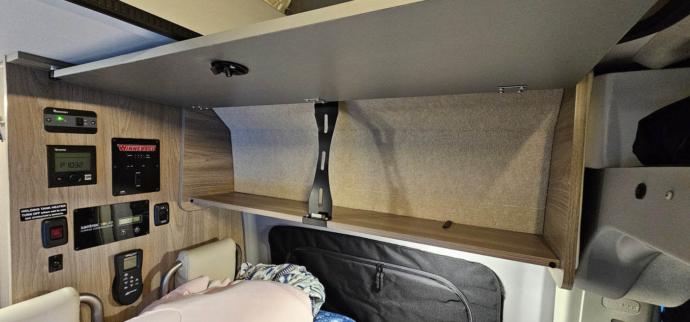 RV rental interior: Overhead cabinet & tech control panel with gauges/switches.