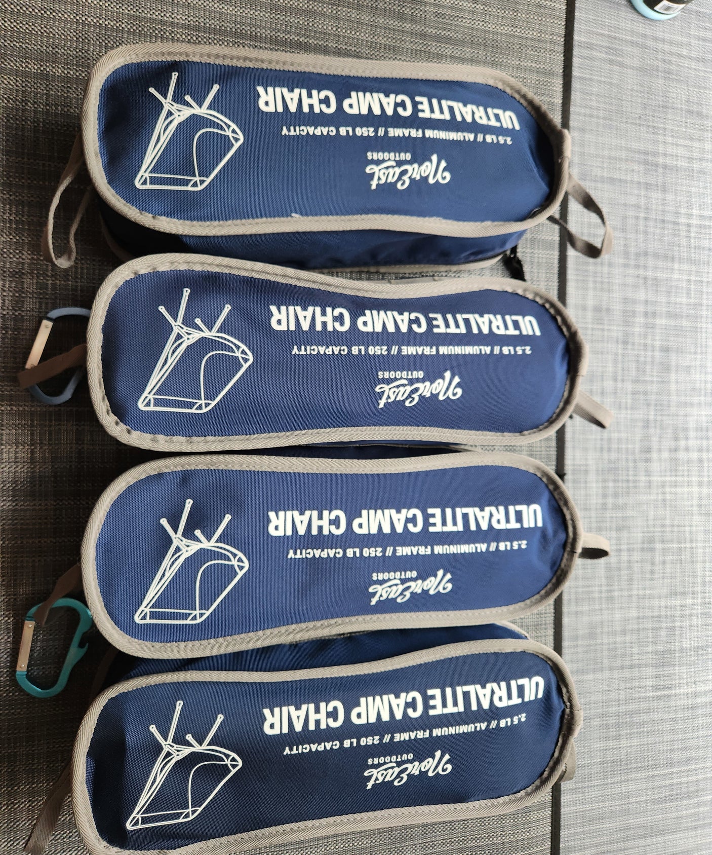 Four dark blue NorEast ultralite camp chairs in bags, weighing 2.5lb each. Ideal portable outdoor gear for an RV rental.