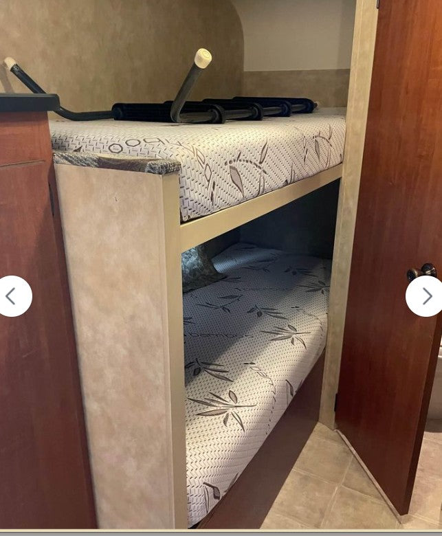 Comfortable bunk beds for your RV rental adventure! Two mattresses with a leaf pattern provide cozy sleeping in this RV interior.