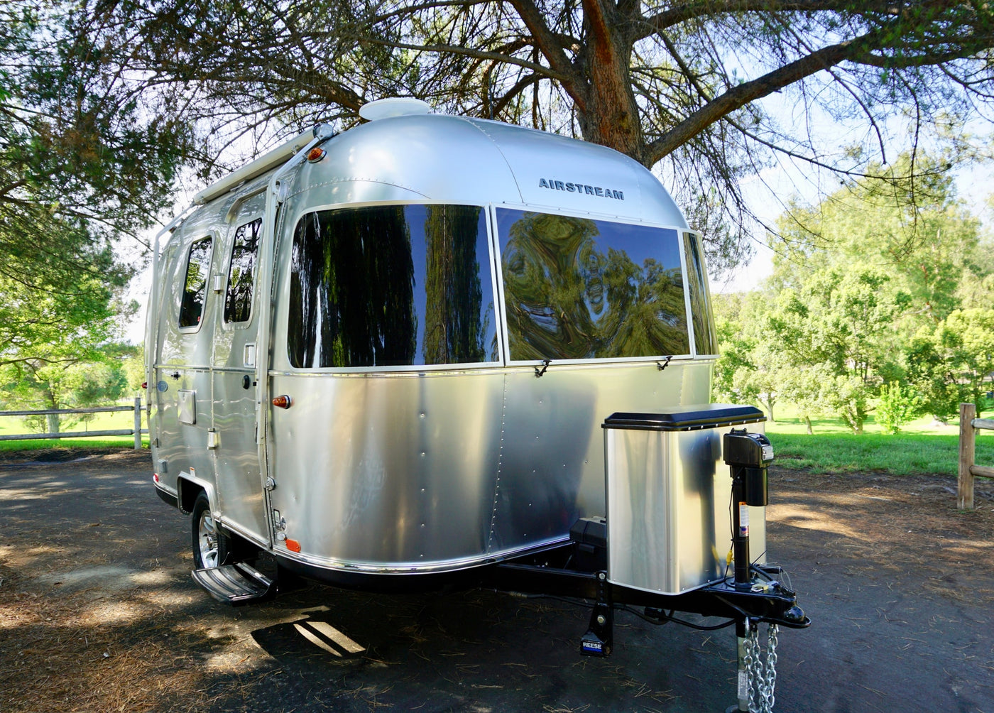 Silver Airstream travel trailer RV rental parked under trees. Ready for your next camping vacation outdoors. — photo 3