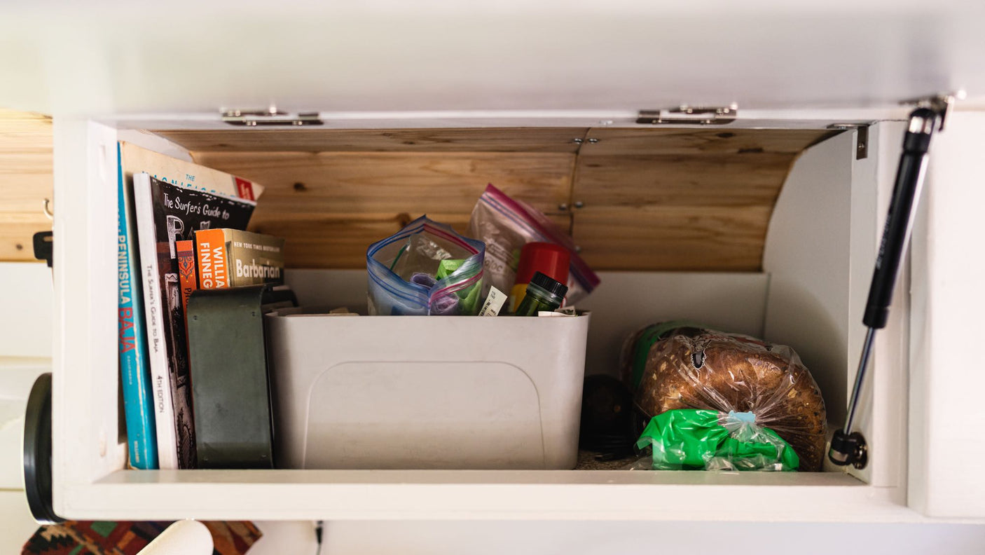 integrated into a wooden counter.|Modern black sink/faucet and wood counter in a compact rv rental kitchen
