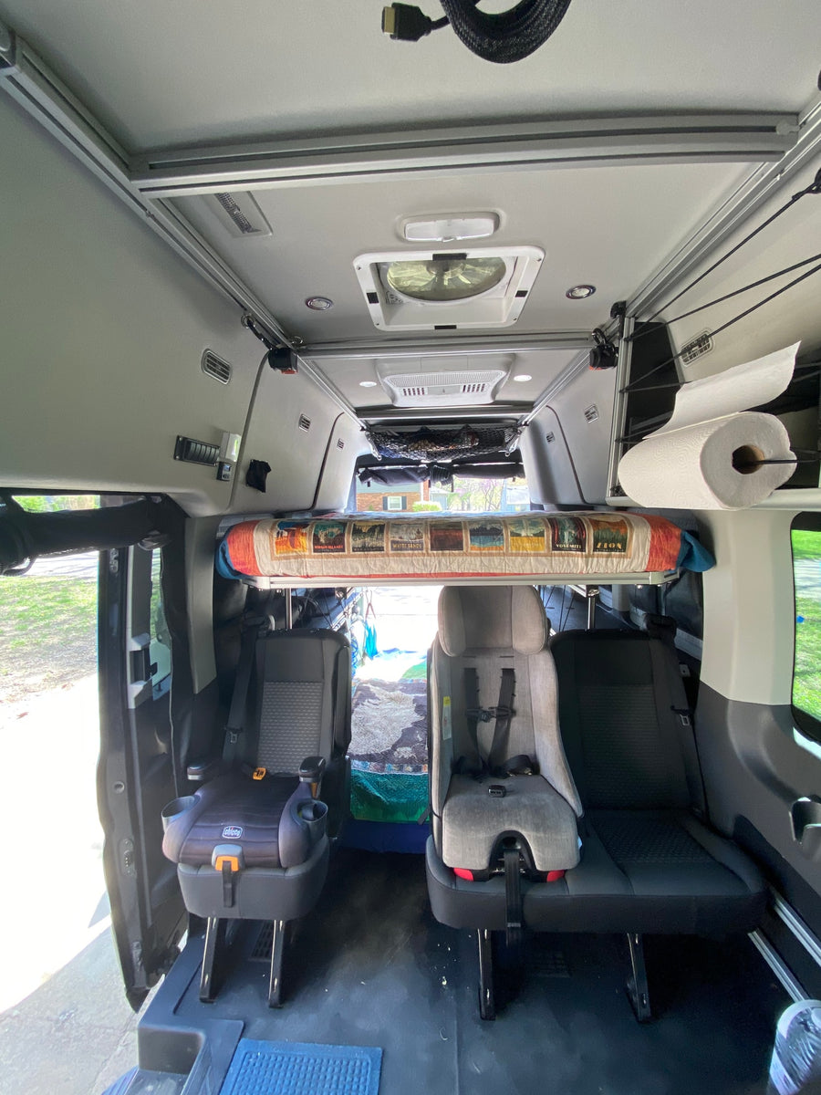 RV rental interior features overhead bunk, child seats, ceiling fan, and storage for family trips.