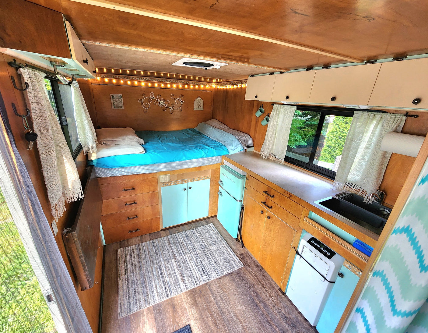 bunk beds & outdoor view.|Inside a cozy RV rental: features a comfortable bed