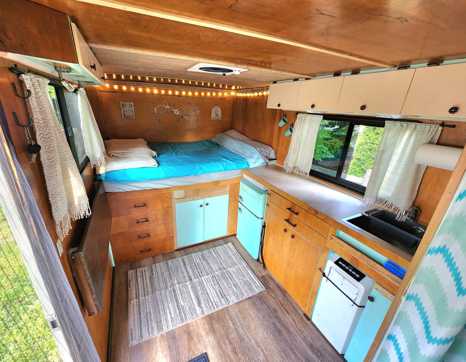 bunk beds & outdoor view.|Inside a cozy RV rental: features a comfortable bed