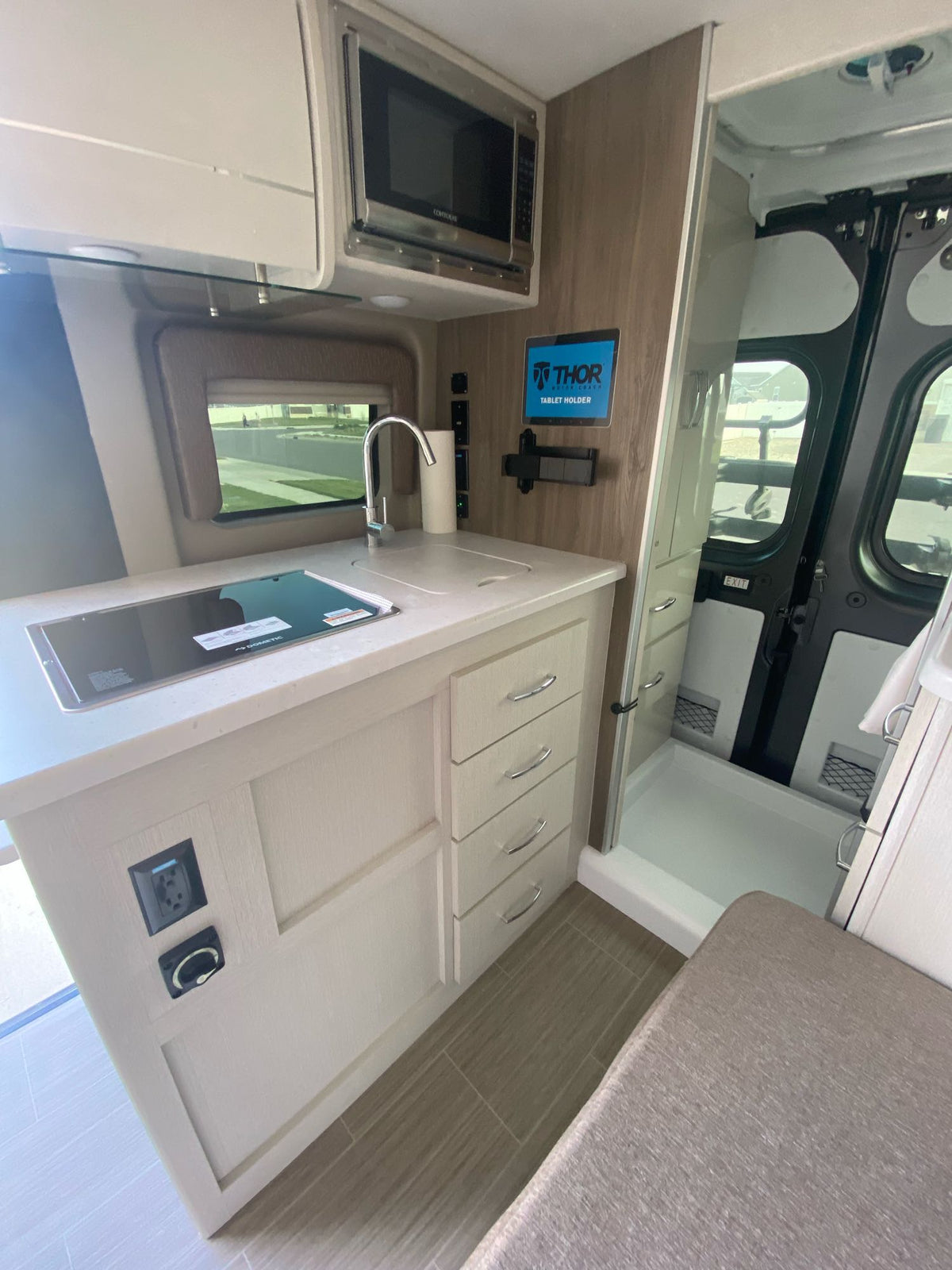 and window view of nature.|Inside an RV rental: a spacious driver's cockpit with steering wheel — photo 18