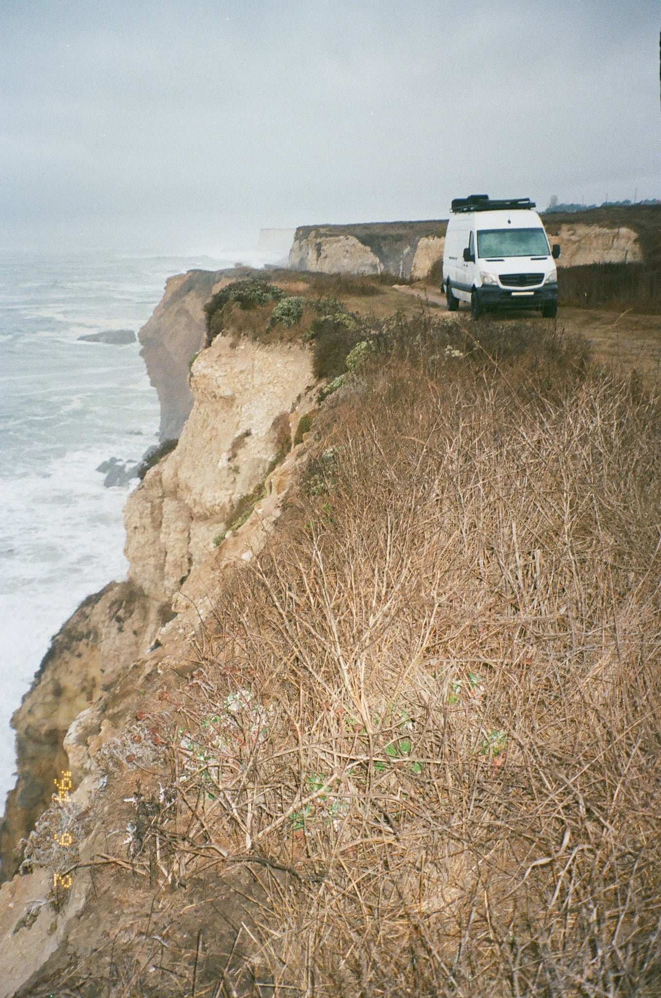 showcasing the compact and functional interior perfect for travel adventures.|White Mercedes Sprinter camper van (RV rental) at foggy sunrise — photo 17