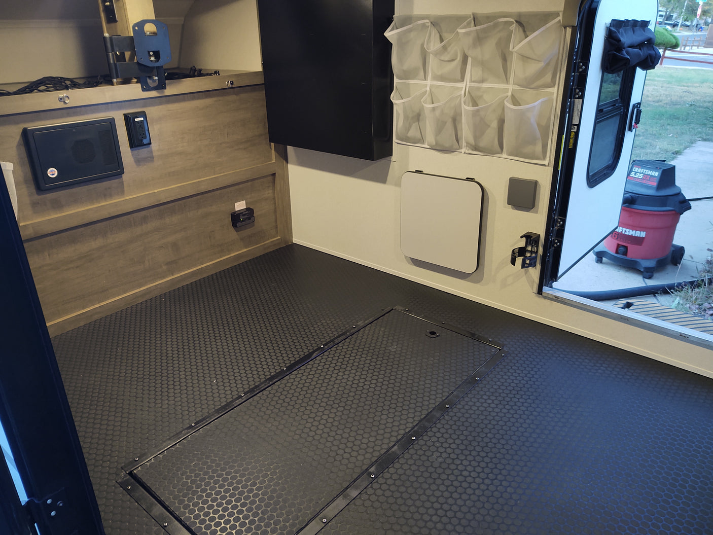 RV rental interior: patterned floor, wall-mounted organizer & folding table. Practical space for travelers.