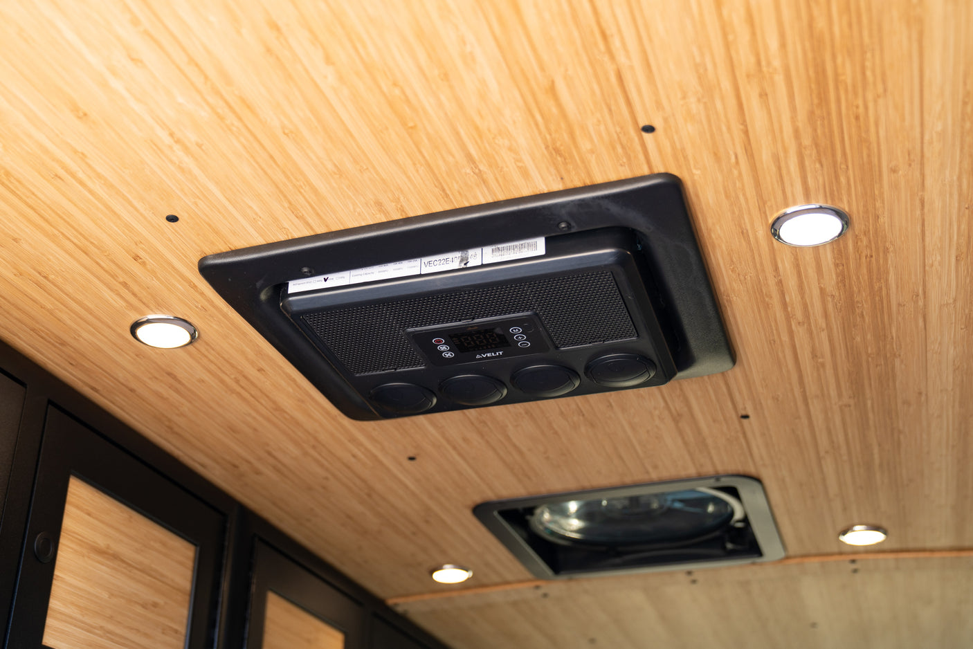 RV rental interior ceiling featuring an AVELIT climate control unit, bright LED lights, and a roof vent for passenger comfort.