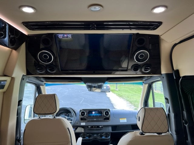 Luxury RV rental interior with TV, speakers, and plush front cabin. Ideal for comfortable road trips.