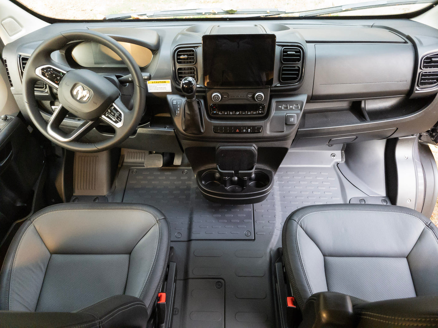 Spacious rv rental cockpit featuring a Ram steering wheel, large touchscreen, and comfy seats with durable floor mats.