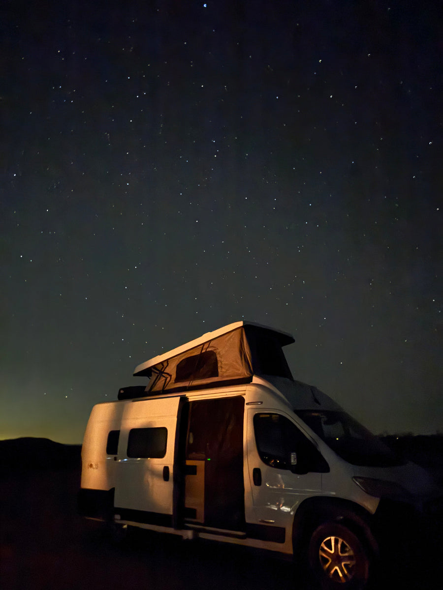 and desert view through the open rear. Ideal for mobile living and road trips.|Cozy RV rental kitchen setup with desert views
