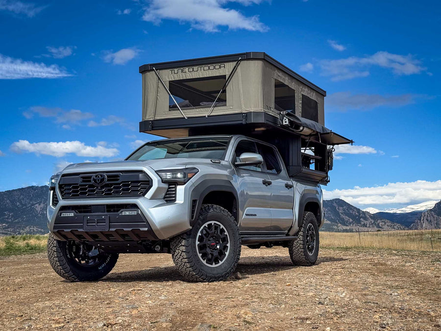 Silver Toyota Tacoma truck with a large Tune Outdoor rooftop tent