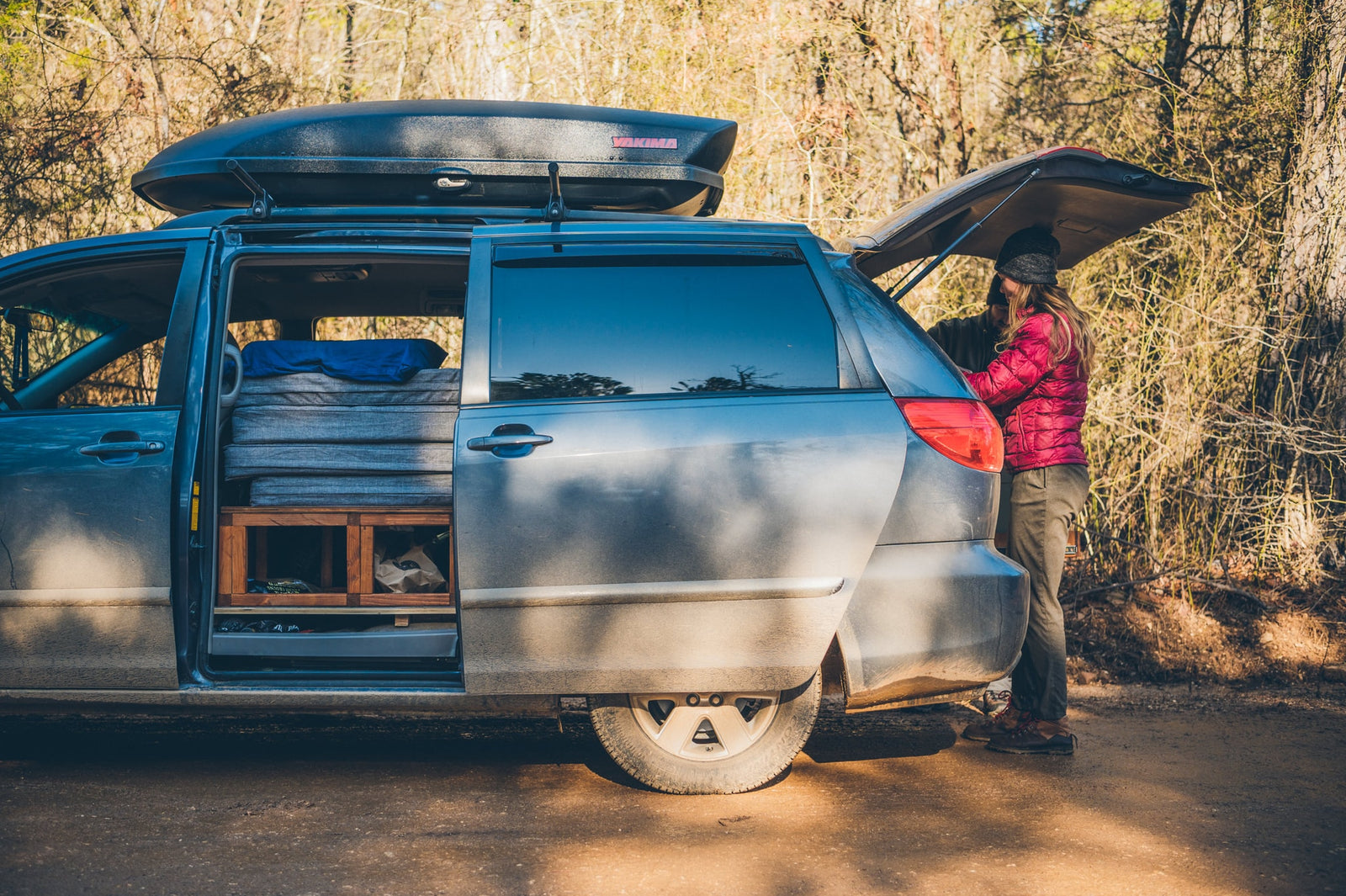 and salt.|An RV rental provides kitchen convenience. A woman preps a red onion for cooking from the open trunk