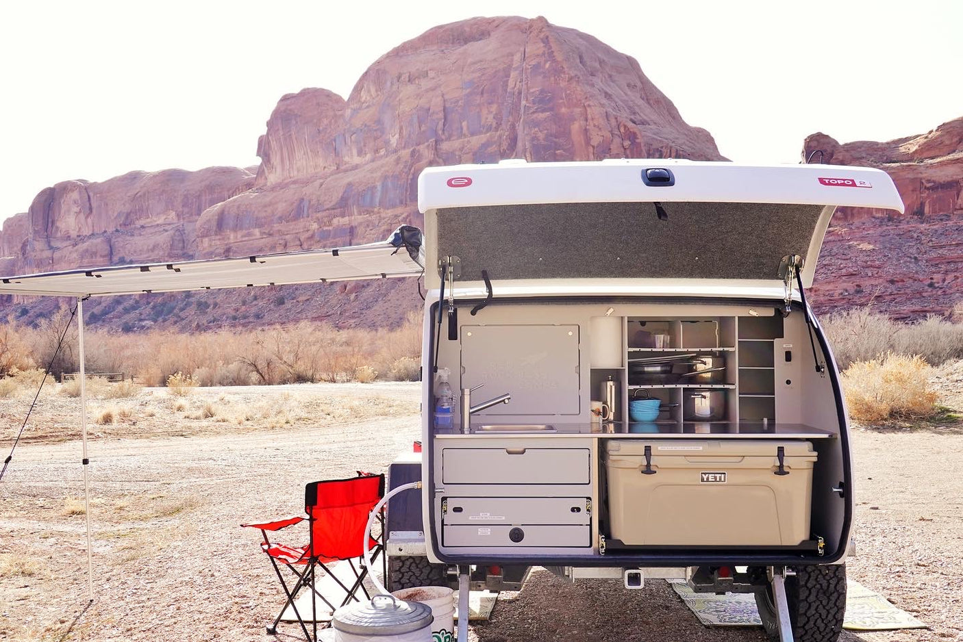 Explore off-grid! This RV rental teardrop camper boasts an outdoor kitchen with sink & cooler, ideal for desert adventures.
