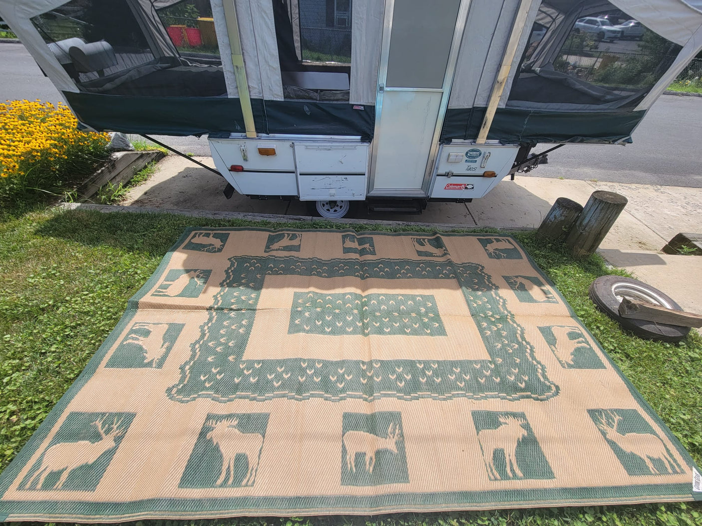 showcasing its roomy interior and outdoor mat.|This white and green pop-up camper is fully set up