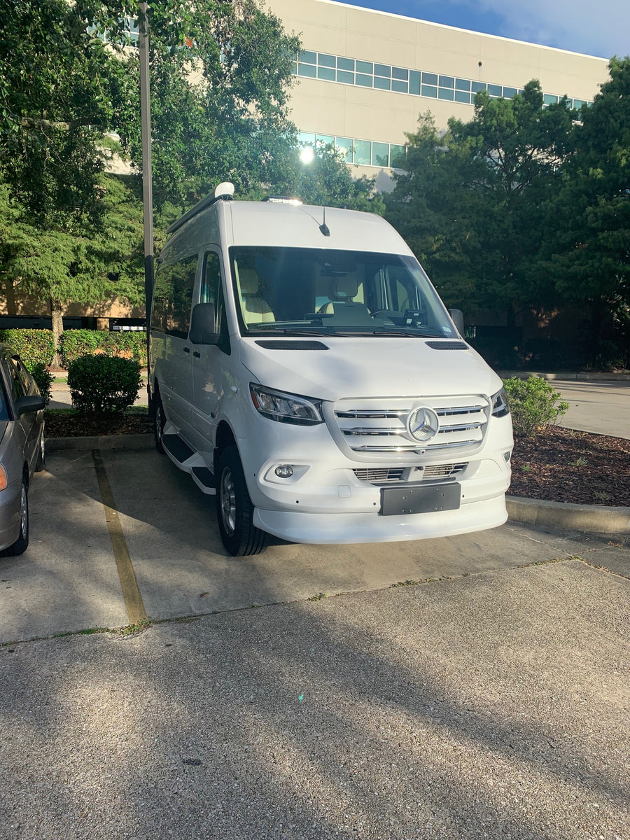 is parked on an asphalt lot beside a mulched planter.|A curious
