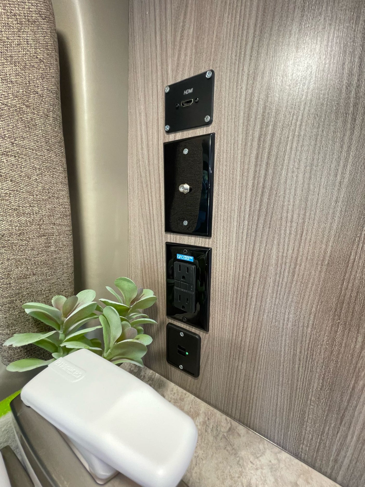 RV rental wall panel with HDMI, coax, power outlets, and USB ports. Essential connectivity for your journey.
