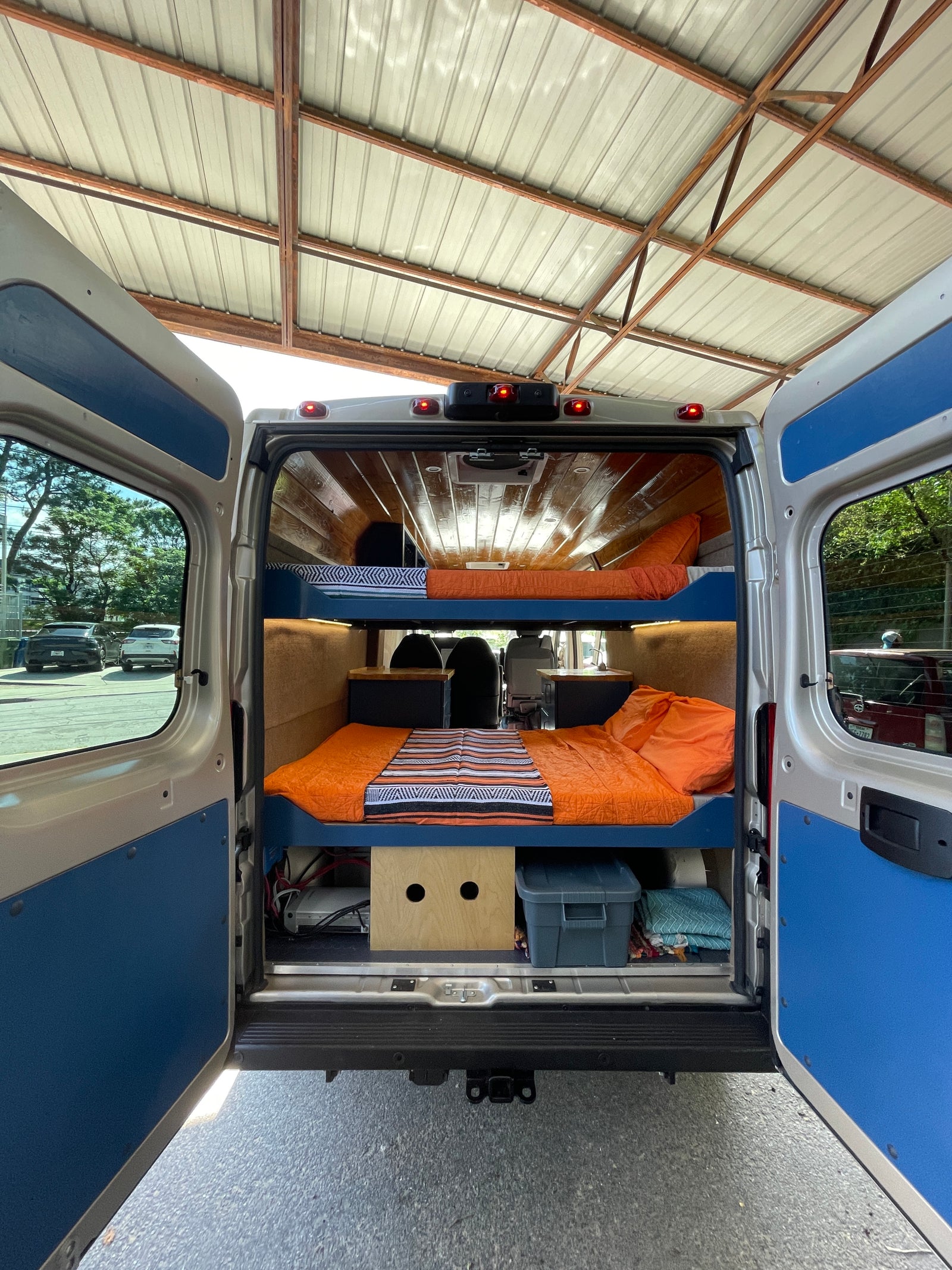 and sleek kitchenette with storage.|RV rental interior with a person on the top bunk