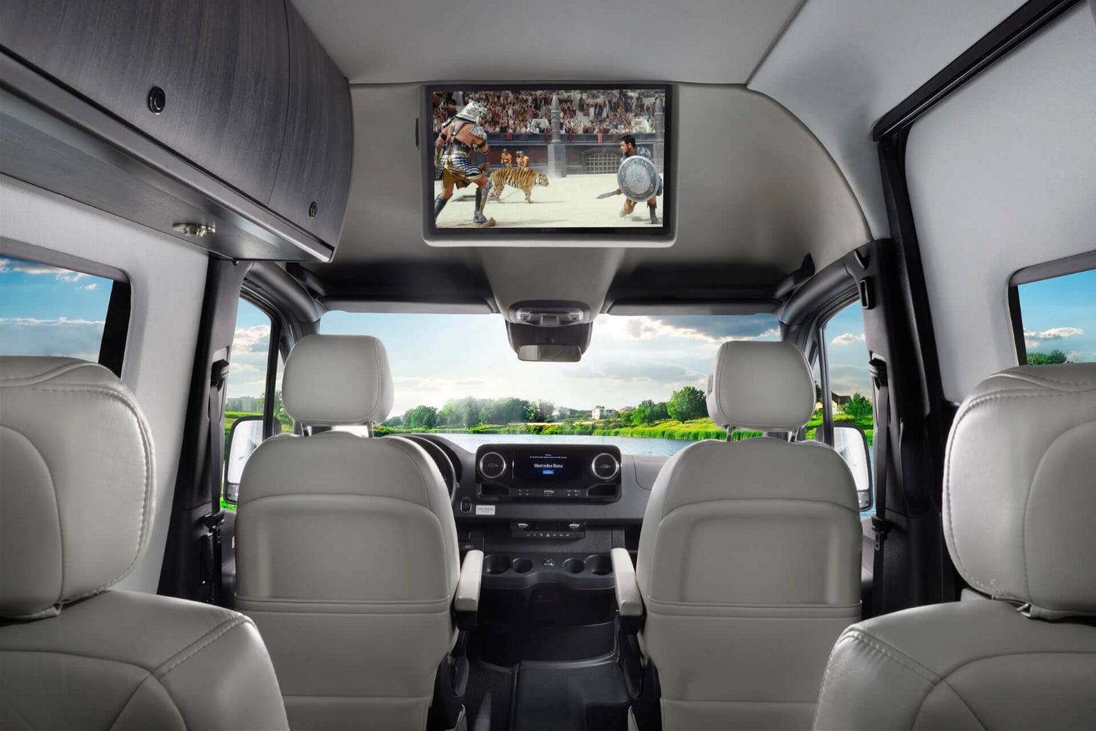 Enjoy a luxury RV rental! View the spacious Mercedes-Benz Sprinter interior with an overhead TV and scenic window views.