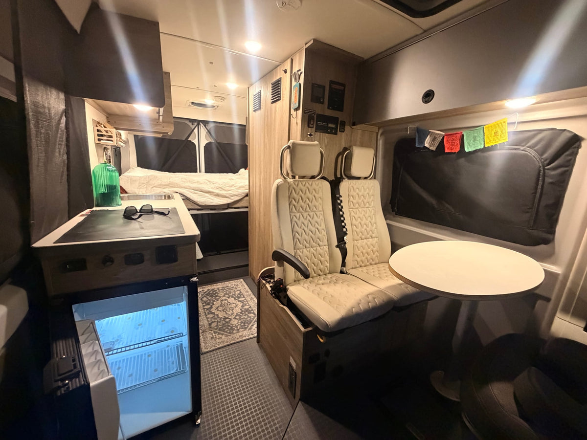 and small freezer.|Cozy RV rental interior features a comfortable — photo 19